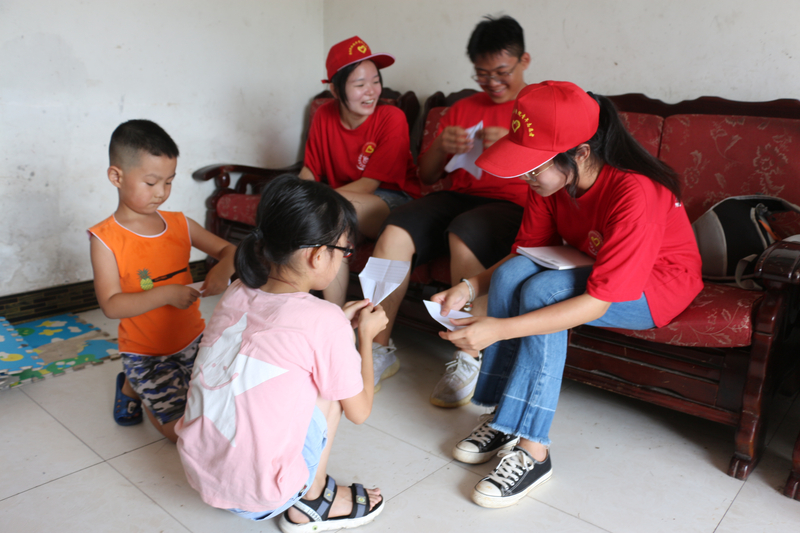 1596688959026029336.jpg 图5-志愿者们与留守儿童一起折纸飞机.jpg